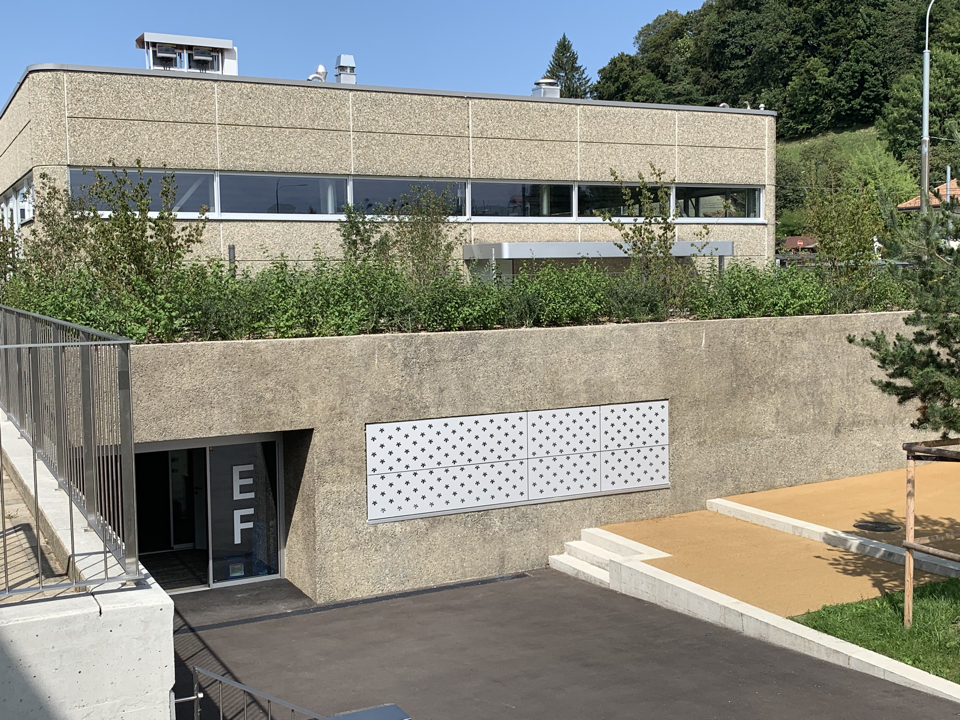 La matérialité de l'extension, un béton désactivé, fait écho au béton lavé des constructions existantes.
