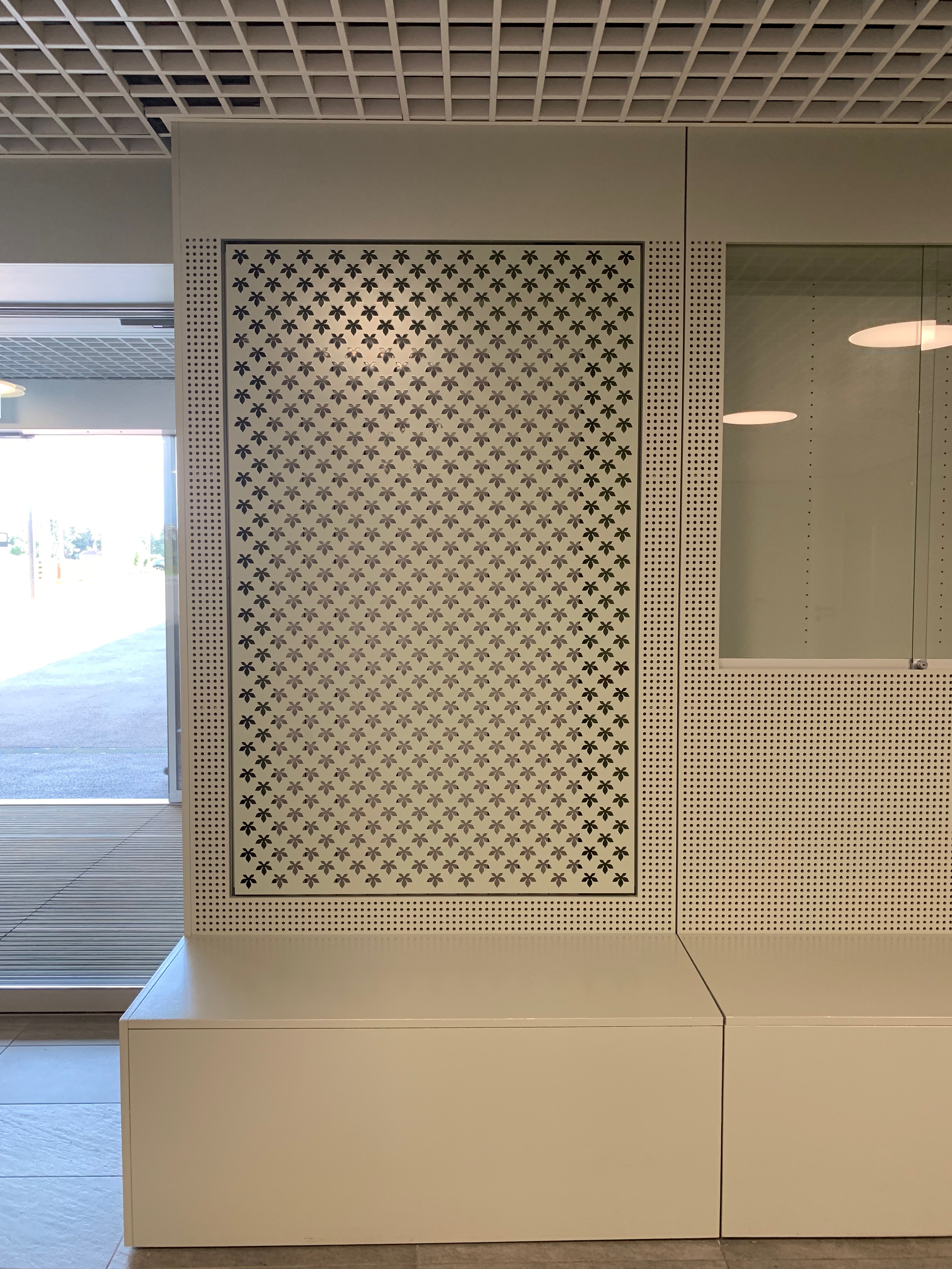 Hall d'accueil : détail du cache radiateur, du banc et d'une vitrine d'exposition.